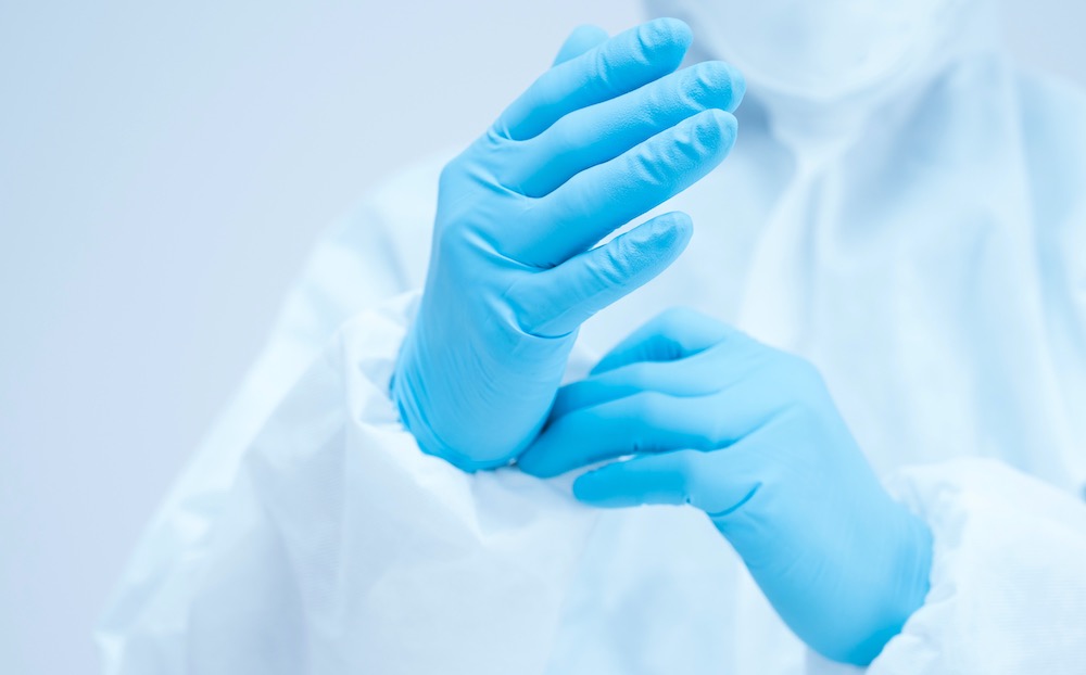 Infirmière enfilant des gants chirurgicaux