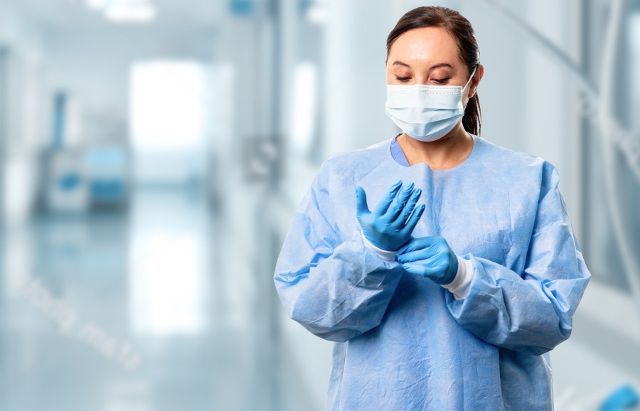 Person donning surgical gloves